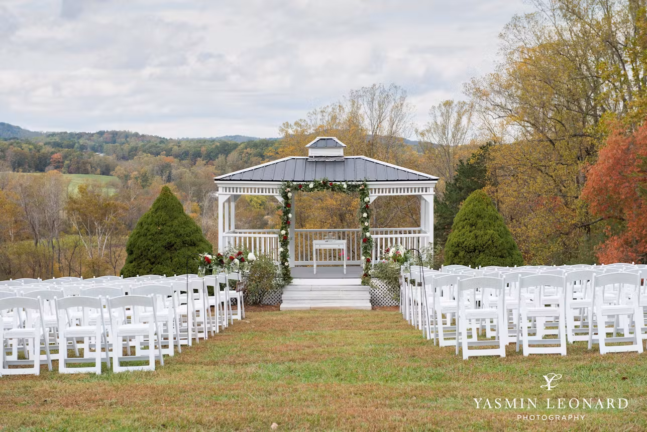 A lush garden gazebo at Rosa Lee Manor, surrounded by blooming vines and set up with white tables and chairs for an outdoor wedding reception.