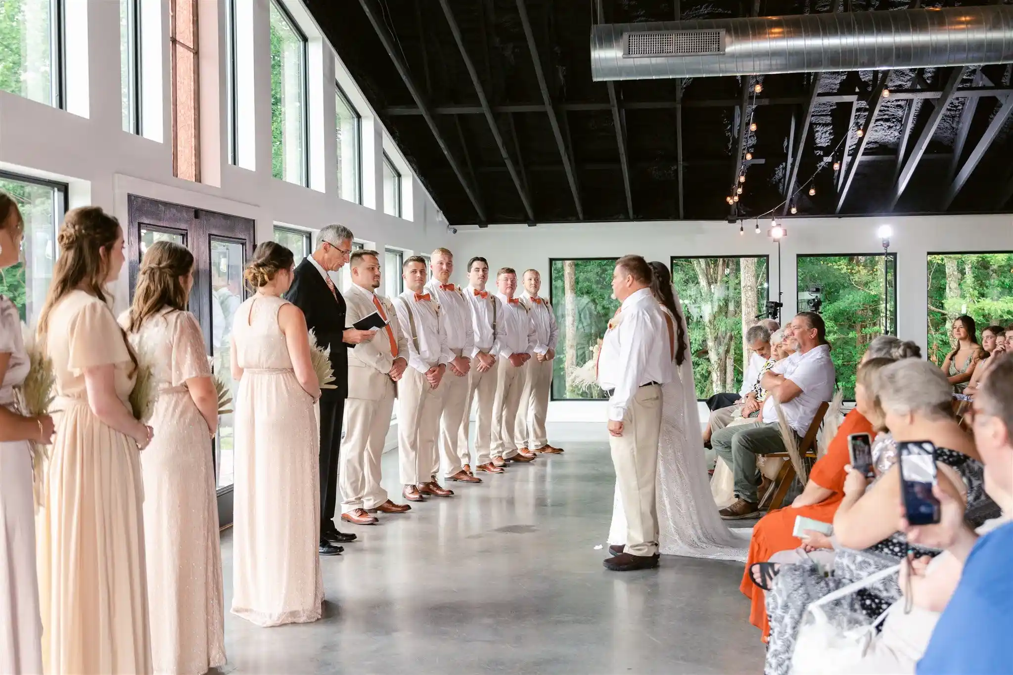 Guests take photos mid ceremony during a photo moment. Photo by Brennan Rieder Photography at Holly & Lucas's 2022 wedding at The Shiloh, Lowgap, NC
