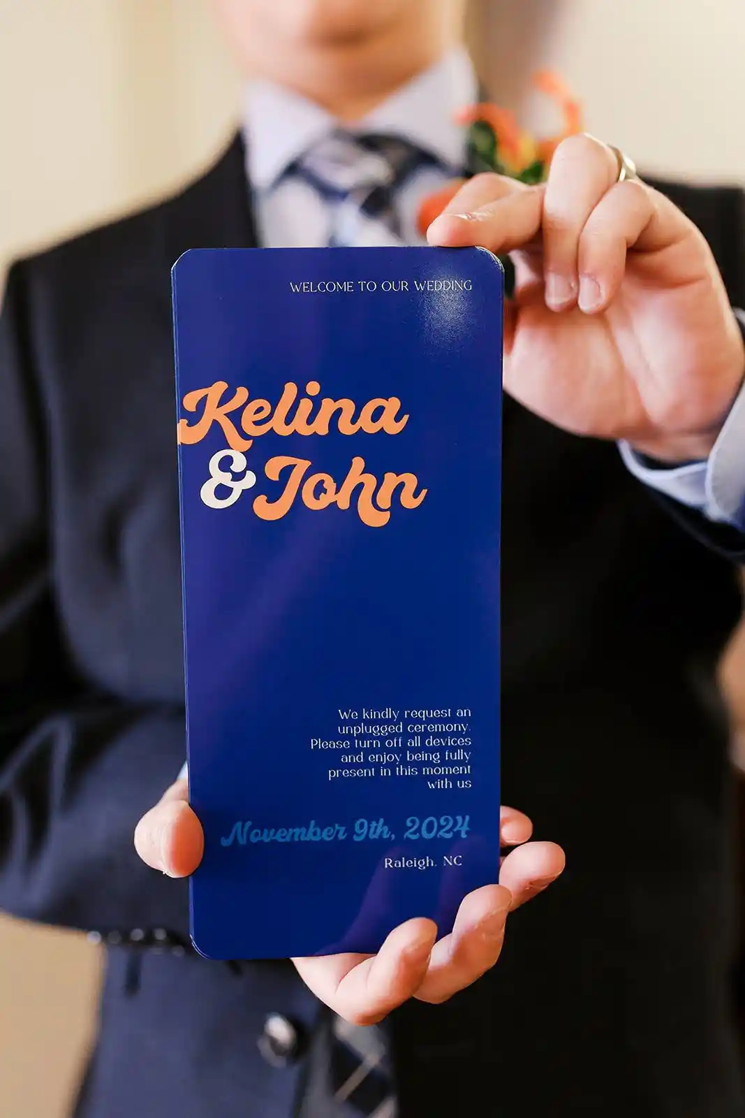 A wedding ceremony program kindly requests an unplugged ceremony. "Please turn off all devices and enjoy being fully present in this moment with us." Photo by Ariel Kaitlin Photography from Kelina & John's 2024 wedding in Raleigh, NC